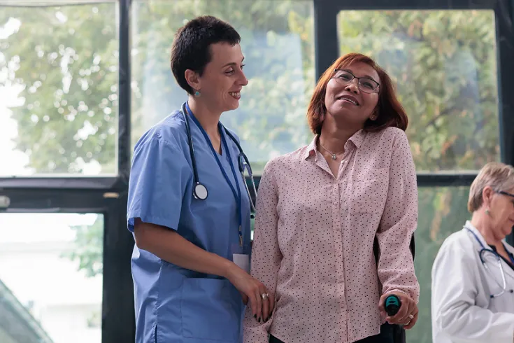 A nurse helping a patient walk